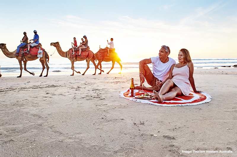 Camels walking past a couple on Cable Beach, Broome credit Tourism Western Australia