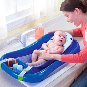 Mom cleaning baby in hammock baby bathtub